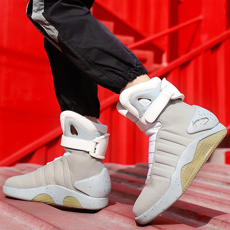 Beige high-top sneakers with white accents worn by a person on red steps.
