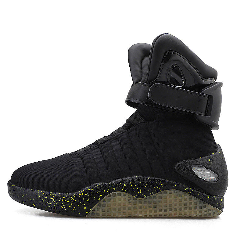 A black high-top sneaker with a strap across the ankle, a translucent textured sole, and small yellow speckles, shown in profile against a white background.