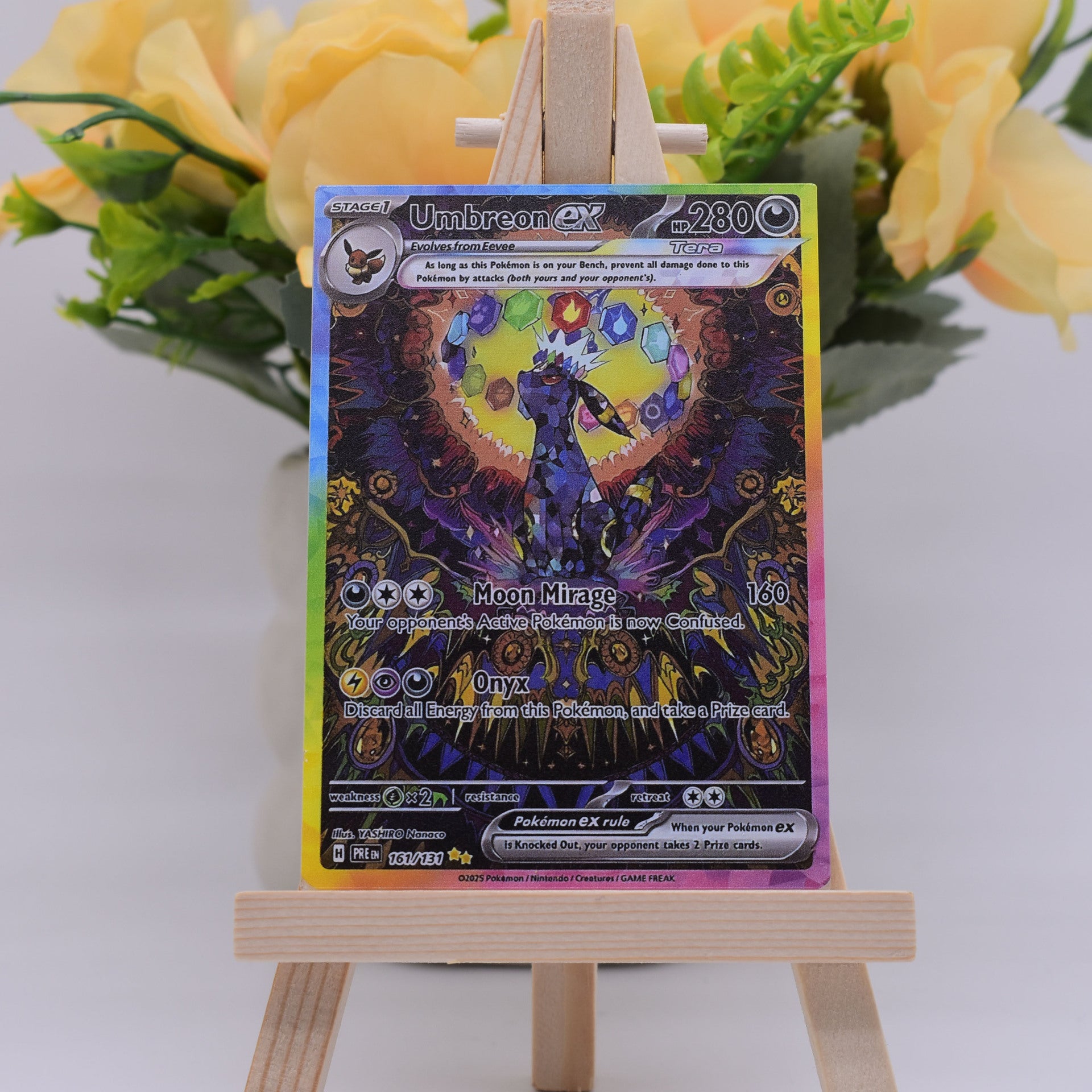 A holographic Pokémon EX trading card featuring Umbreon EX, displayed on a small wooden easel with yellow flowers in the background.