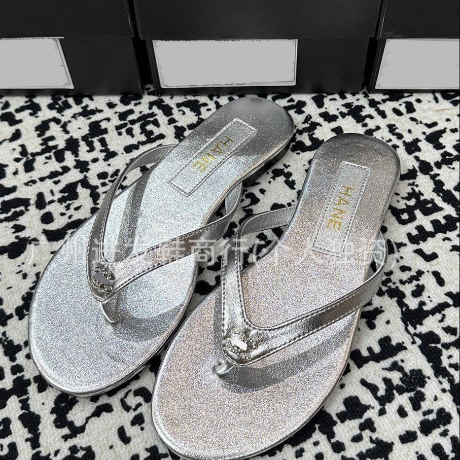 Pair of silver glittery flip-flops on a patterned surface