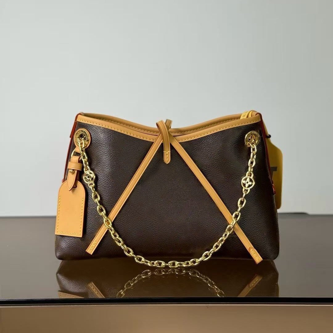 Brown handbag with gold chain and strap on a reflective surface