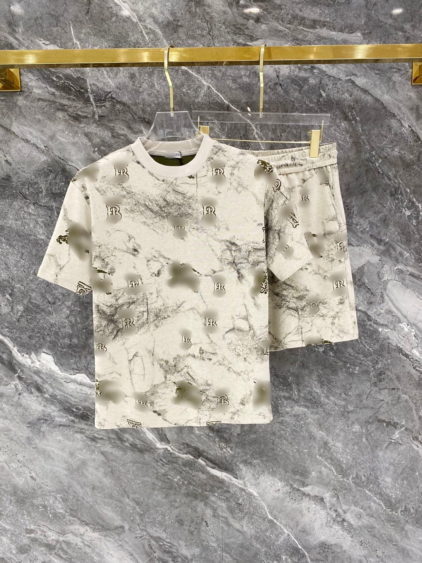 Camouflage-patterned shirt and shorts set on a hanger against a marble background