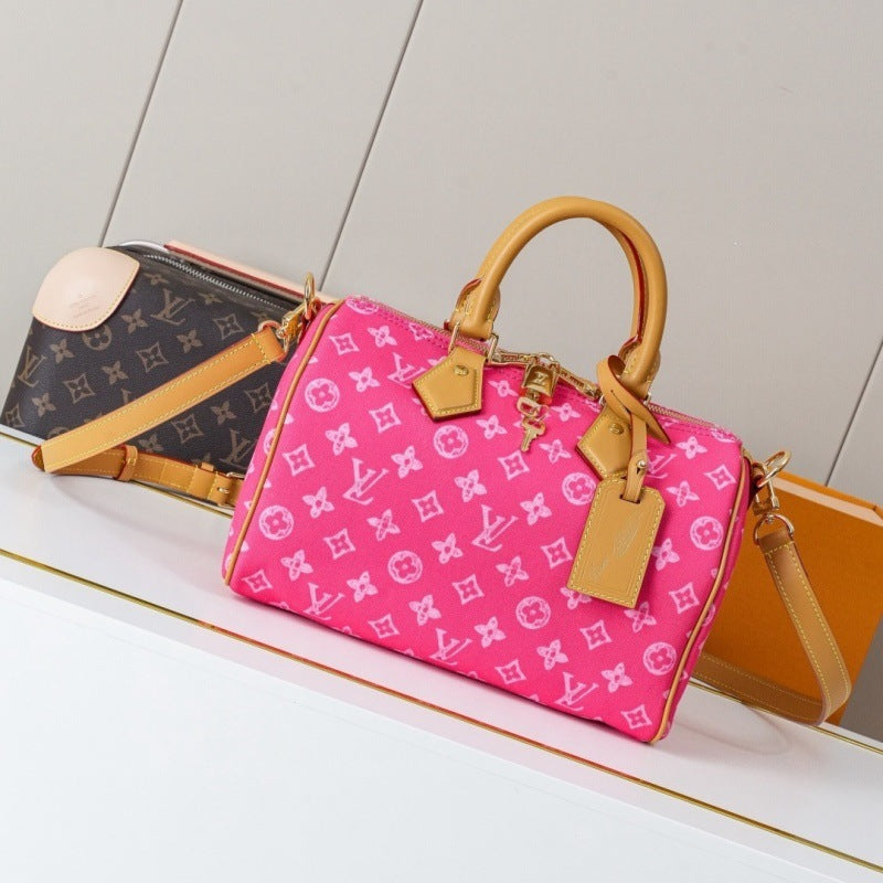 A pink Louis Vuitton monogram Speedy handbag with tan leather handles and a matching pink-and-white monogram crossbody bag, displayed on a white shelf next to a brown Louis Vuitton monogram bag.