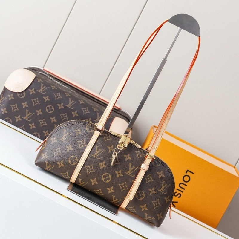 Louis Vuitton monogram canvas duffle bag with light beige leather trim and orange-brown shoulder straps, displayed on a white surface next to an orange Louis Vuitton box.