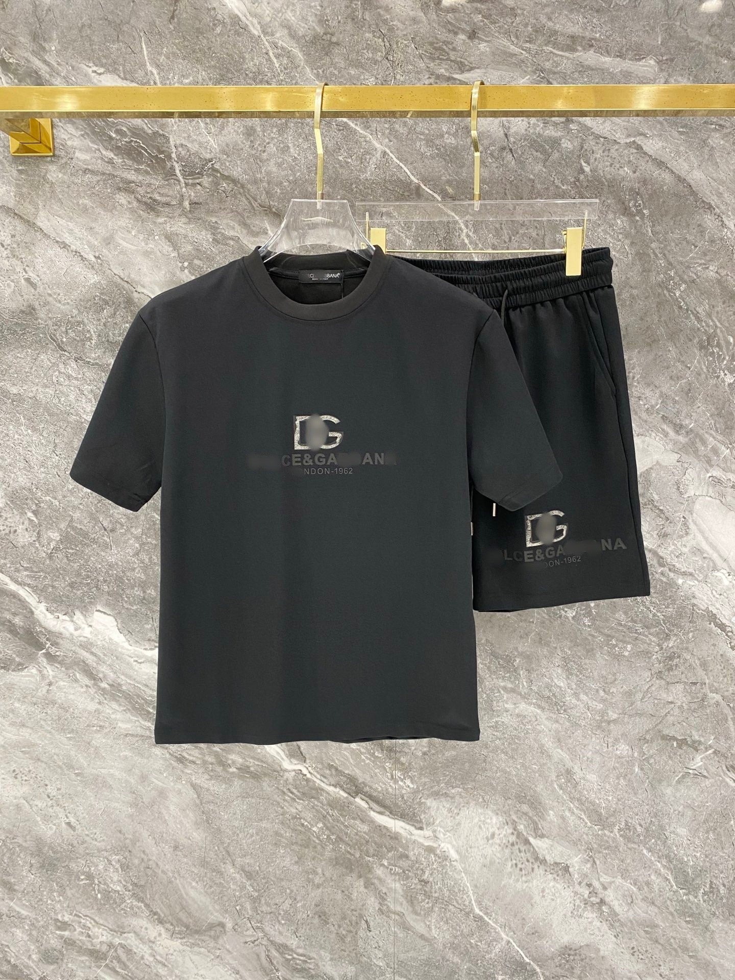 Black t-shirt and shorts set with logo on a marble surface