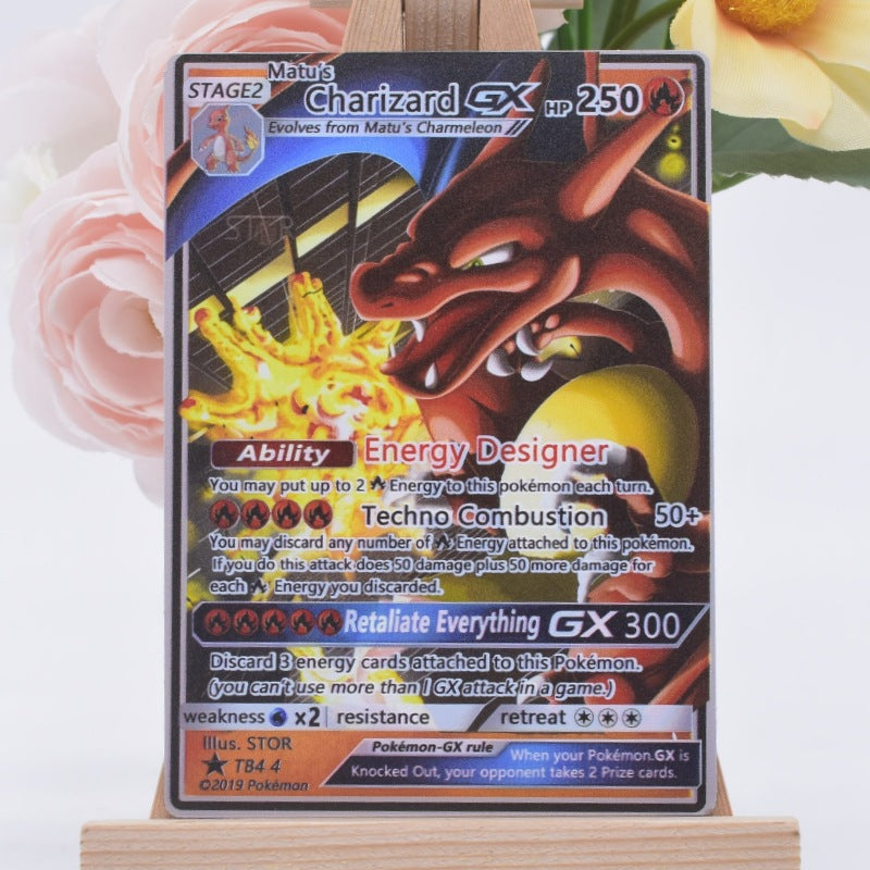 A Charizard GX trading card displayed upright on a small wooden stand, with pink flowers and a yellow flower blurred in the background.