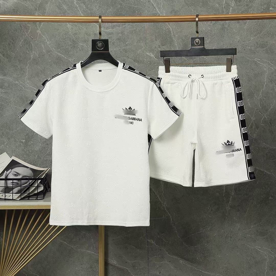 White t-shirt and shorts set with black logo on hangers against a gray background