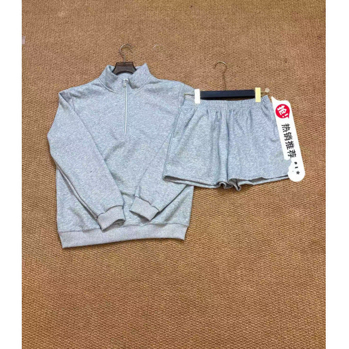 Gray sweatshirt and shorts set with a tag on a brown textured background