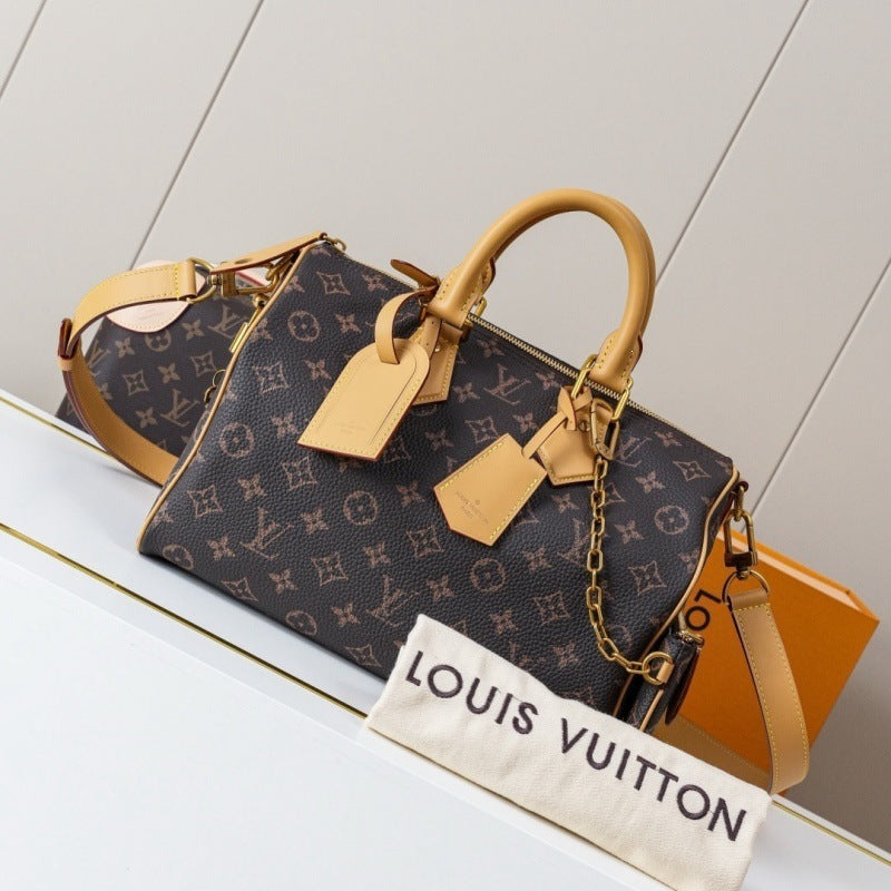 Louis Vuitton monogram Speedy handbag in dark brown coated canvas with tan leather handles and trim, shown with a matching orange Louis Vuitton box and a white dust bag printed with 'LOUIS VUITTON'.