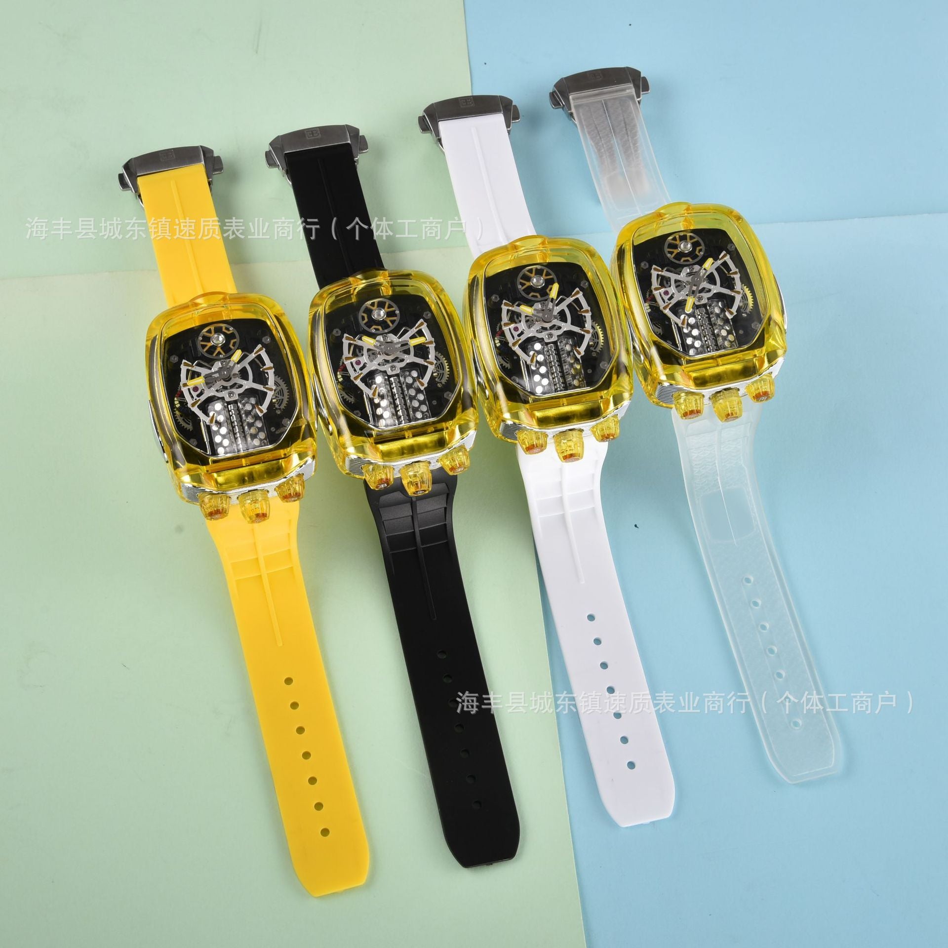 Four toy watches with different colored straps on a light blue and green background