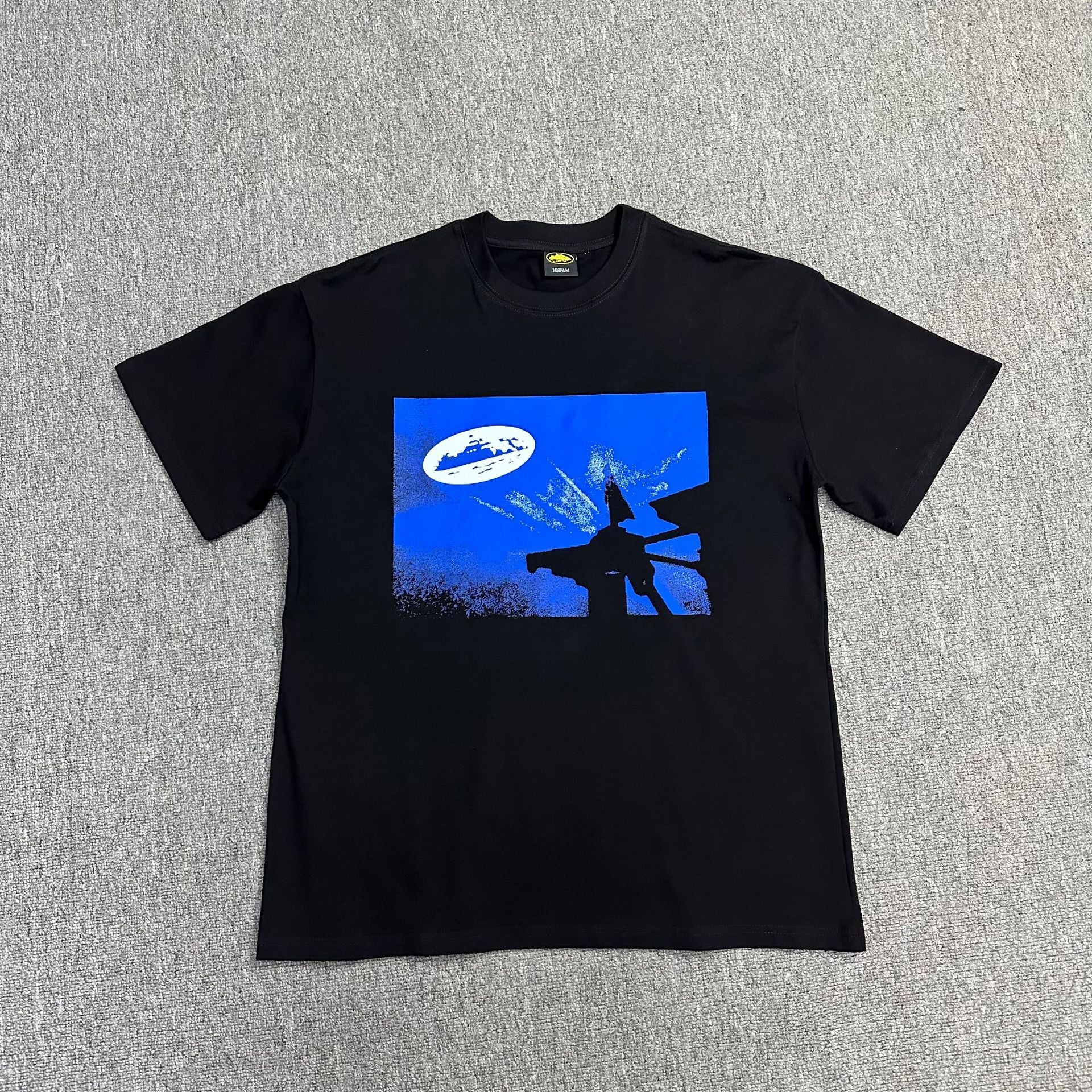 Black t-shirt with blue graphic design on a gray background