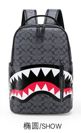 A dark gray Coach backpack featuring a shark mouth graphic on the front with white, black, and red details, shown against a plain white background with Chinese text '椭圆/SHOW' below.