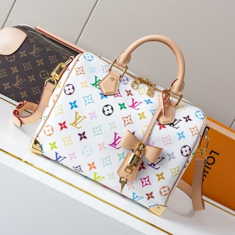 A Louis Vuitton monogram handbag in white canvas with a colorful multicolor monogram print, tan leather handles and trim, and gold-tone hardware, displayed on a white surface with a Louis Vuitton box in the background.