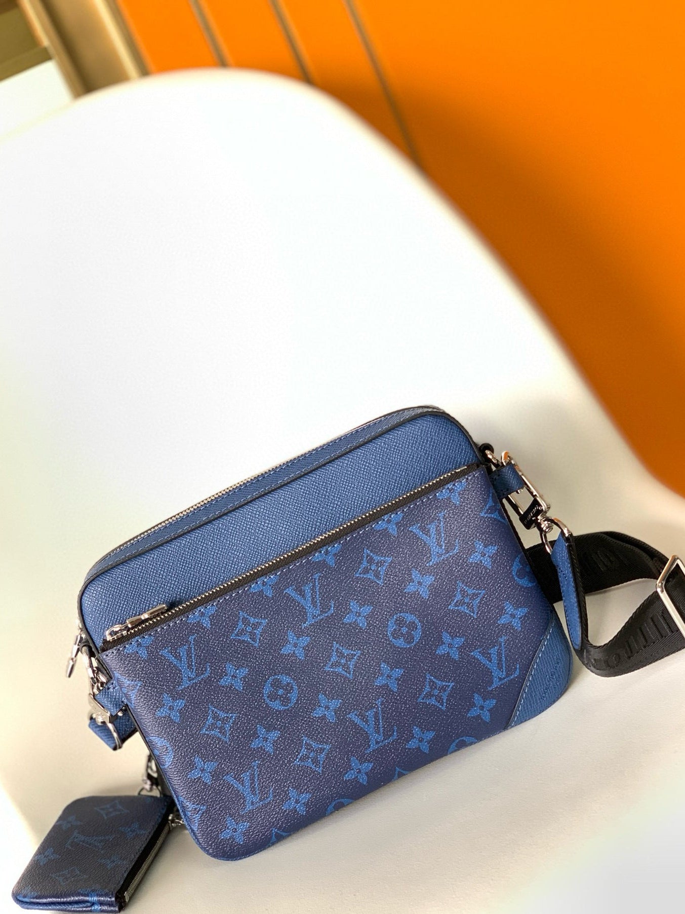 Blue handbag with a brand logo on a white surface