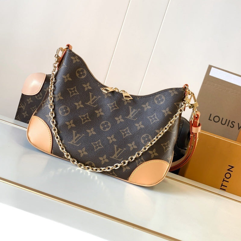 Louis Vuitton monogram canvas shoulder bag with tan leather trim and a gold-tone chain strap, displayed on a white surface next to its Louis Vuitton box.