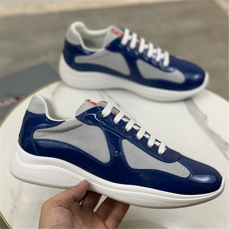 Blue and gray sneakers with white laces on a light surface.
