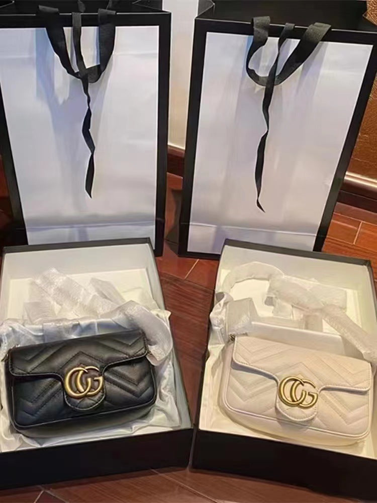 Two quilted leather shoulder bags with gold GG hardware displayed in black boxes with tissue paper and black handles