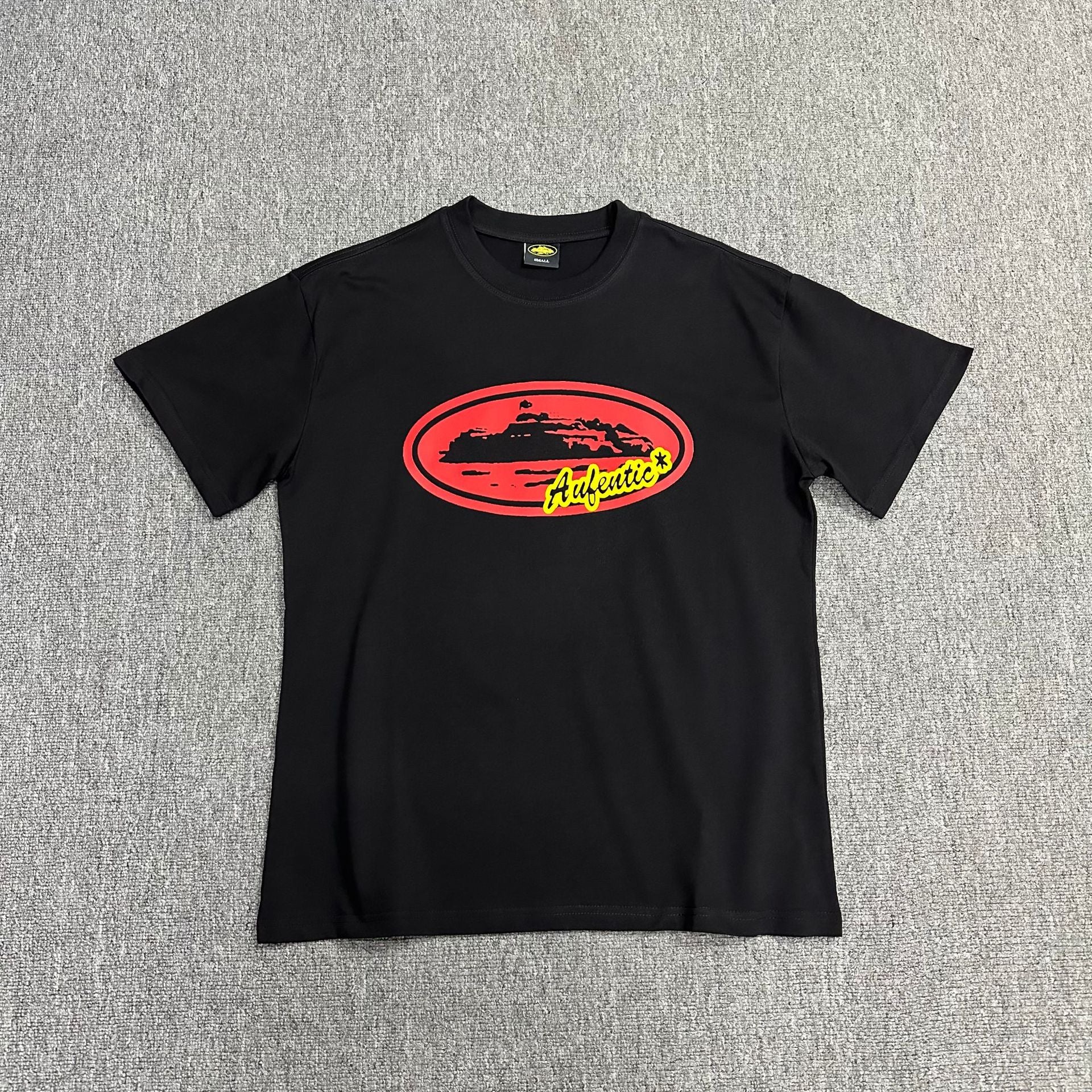 Black t-shirt with a red and yellow logo on a gray background