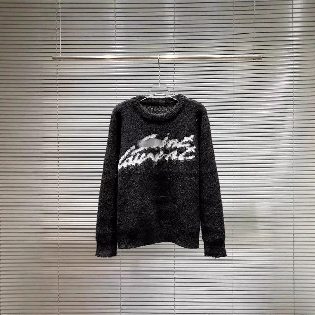 A dark gray fuzzy knit sweater with a white graphic text design across the chest, hanging on a hanger against a background of horizontal window blinds.
