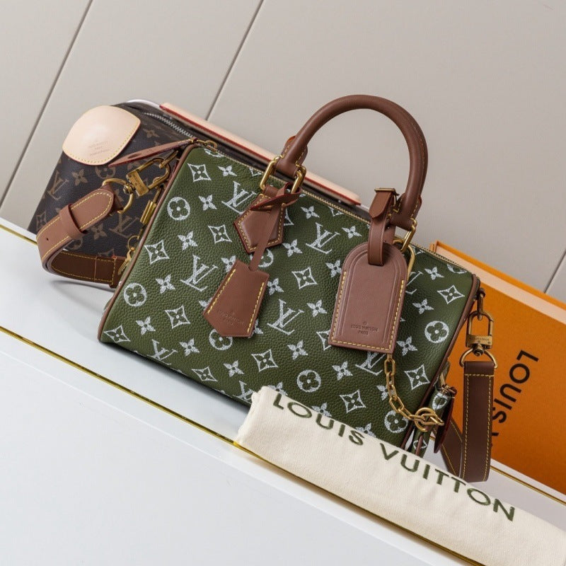 Louis Vuitton monogram handbag in olive green canvas with brown leather handles and trim, displayed on a white surface with a Louis Vuitton dust bag and orange box in the background.