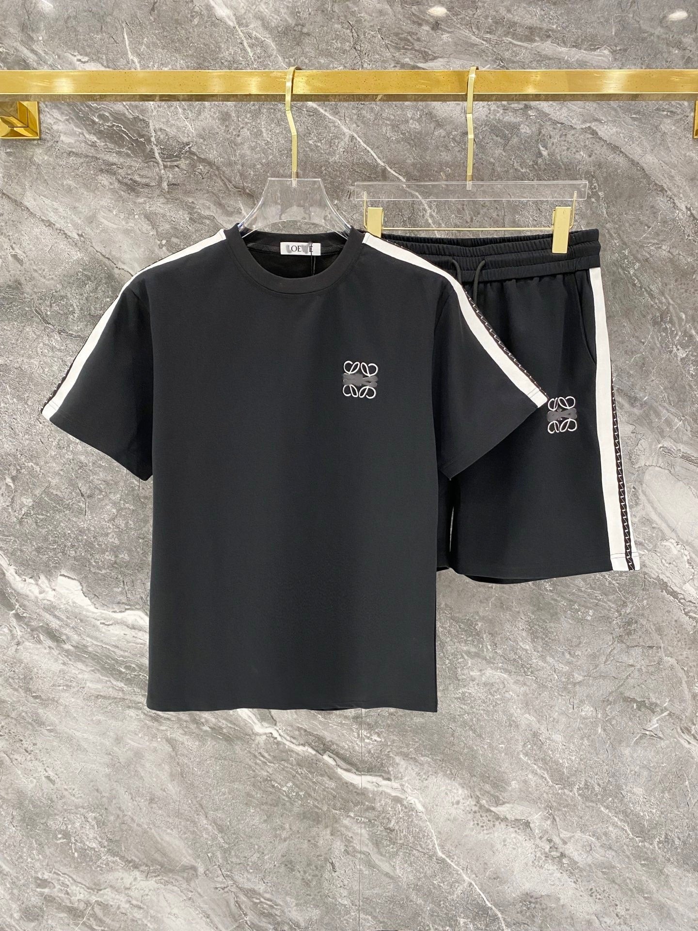 Black t-shirt and shorts set with white accents on a marble surface