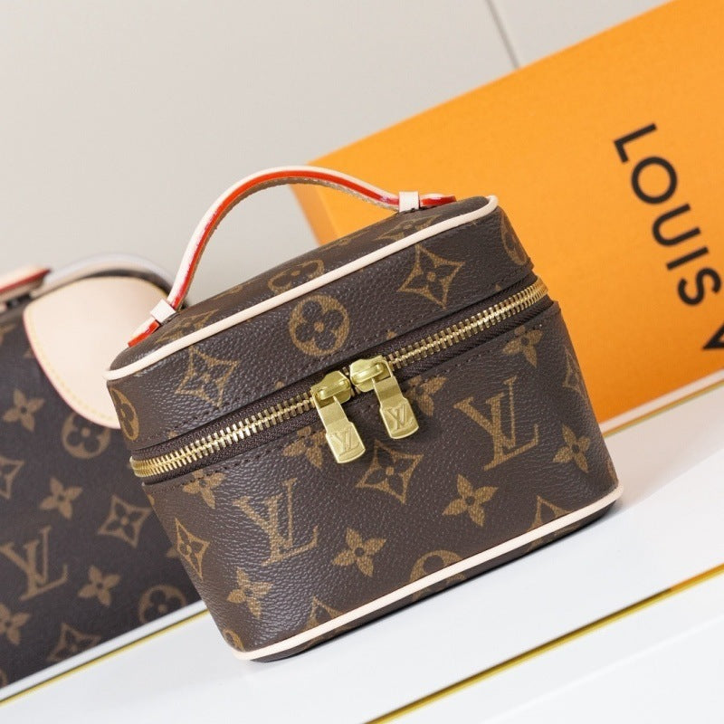 A Louis Vuitton monogram canvas cosmetic bag with a top handle, gold-tone zipper, and gold hardware, shown alongside a matching orange Louis Vuitton box on a white surface.