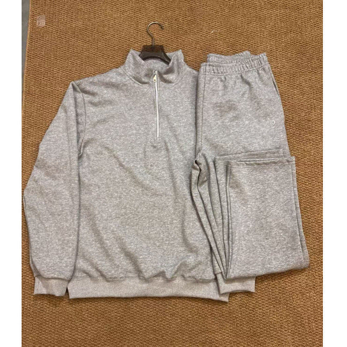 Gray tracksuit on a hanger against a brown background
