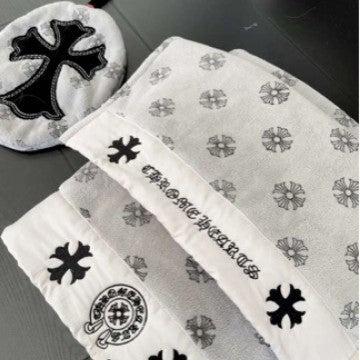 Set of towels with black cross designs on a gray surface