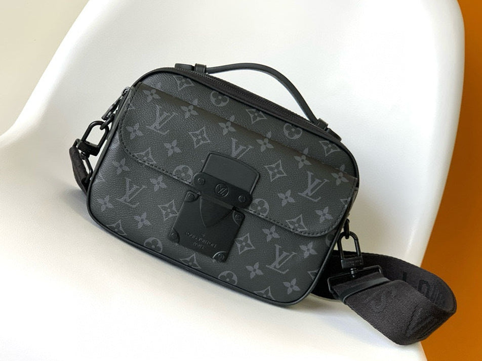 Black patterned handbag on a white chair with an orange background