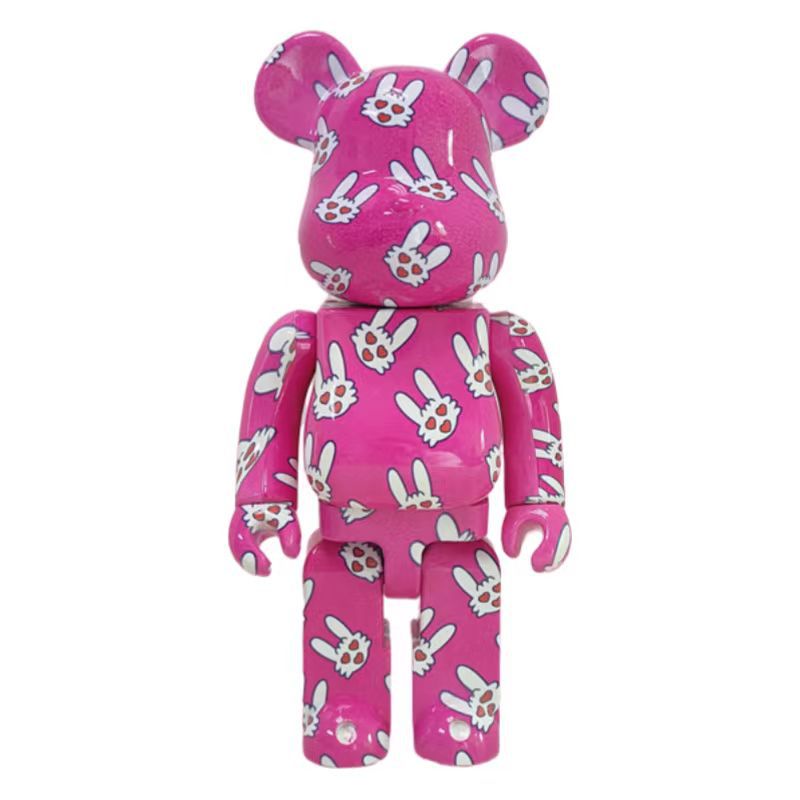 A pink bear-shaped collectible figure covered in a white bunny and flower pattern, shown against a plain white background.