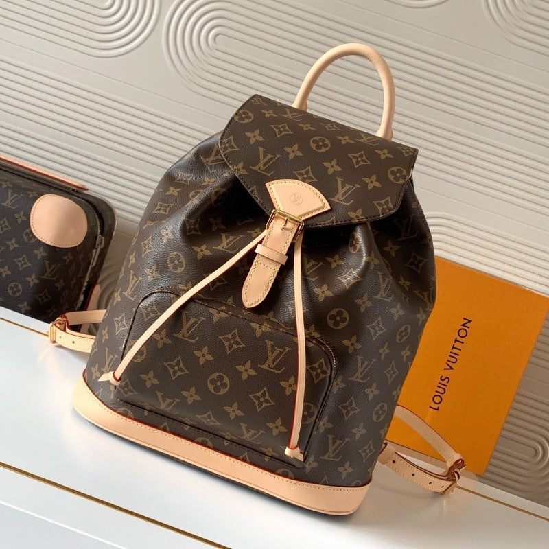 Louis Vuitton monogram backpack in brown coated canvas with beige leather trim, shown on a white surface with a Louis Vuitton box and a matching pouch in the background.