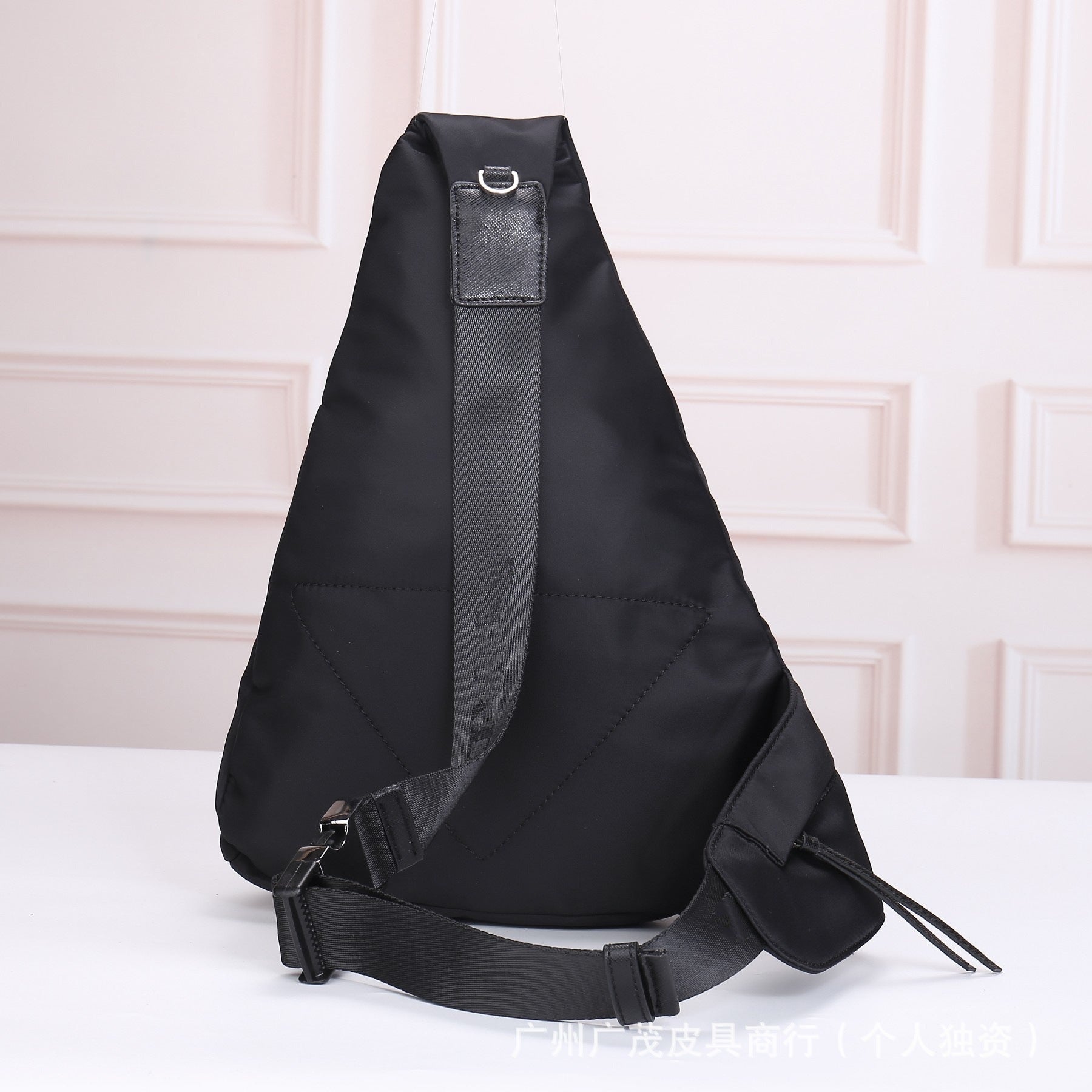 Black sling bag with brand logo on a light background