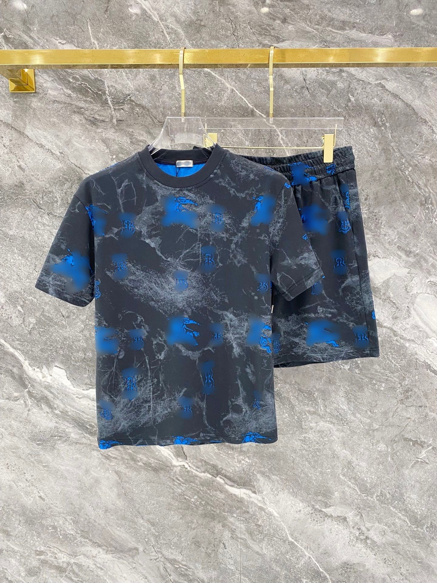 Black and blue patterned t-shirt and shorts set on a marble surface