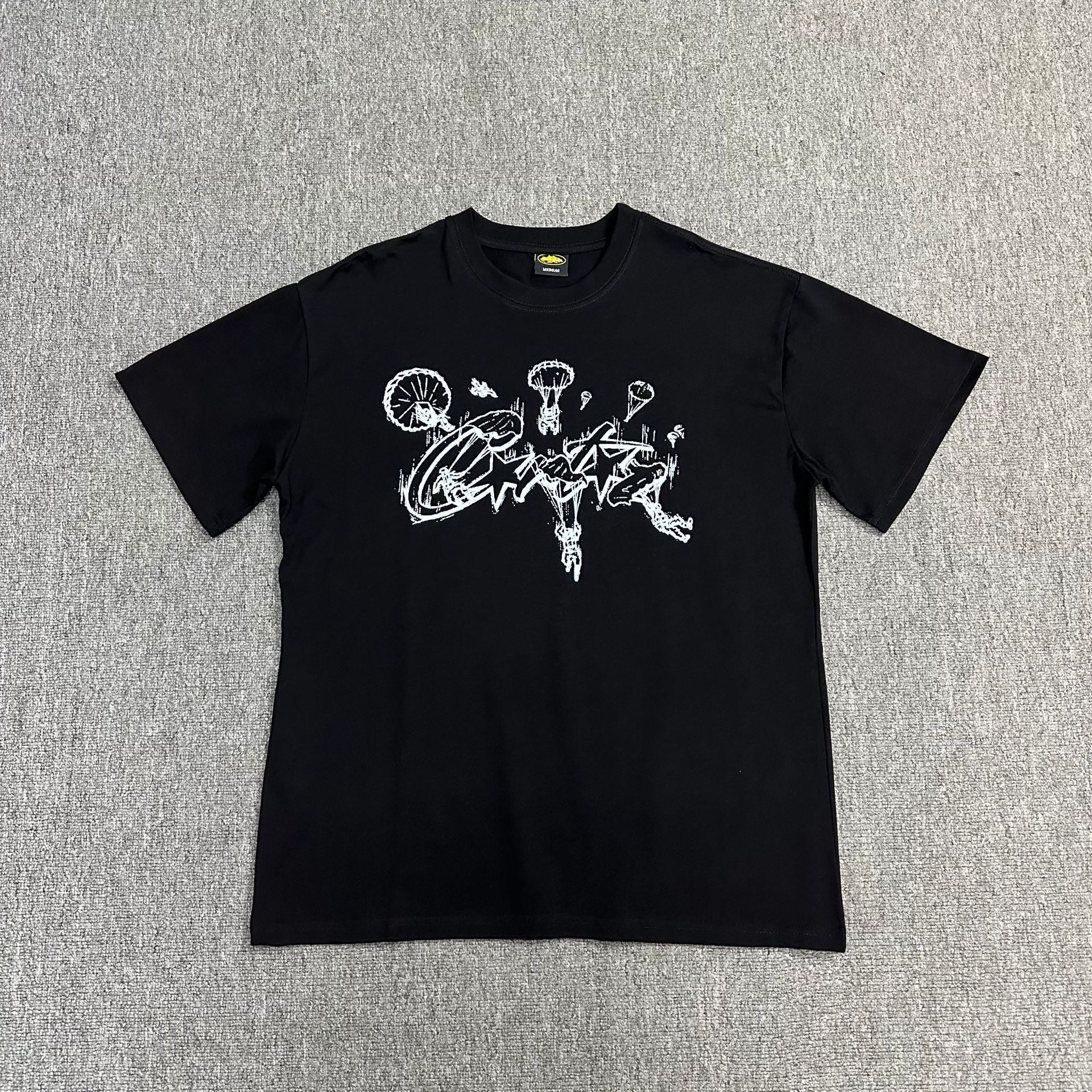 Black t-shirt with white graphic design on a gray background