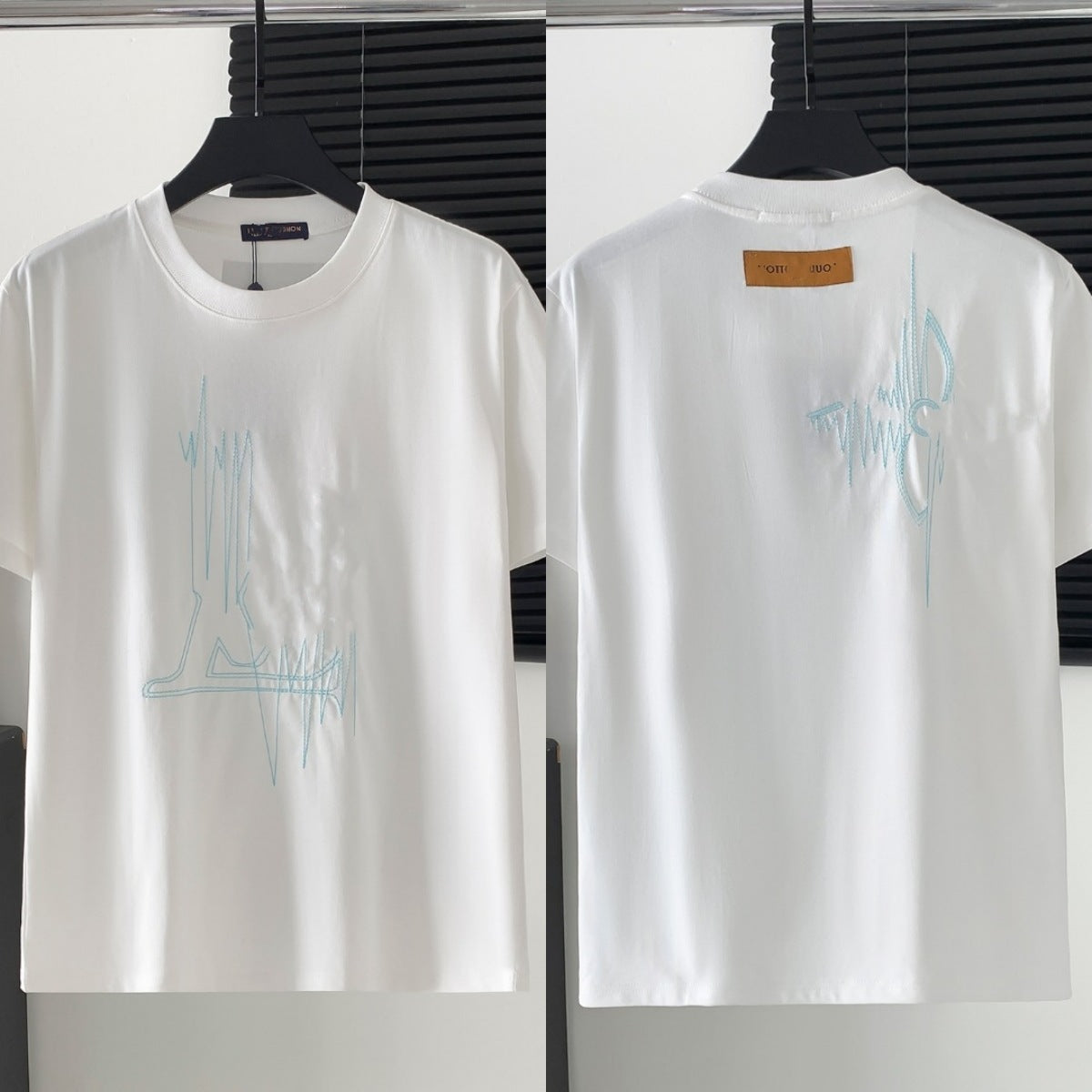 White t-shirt with blue graphic design on a hanger against a white background