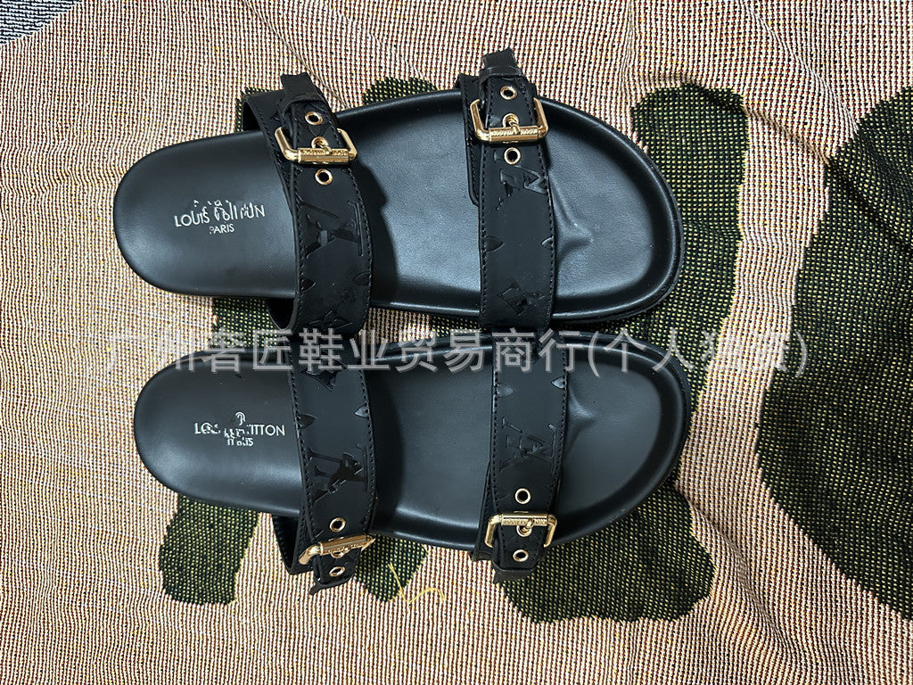 Black sandals with straps on a textured surface