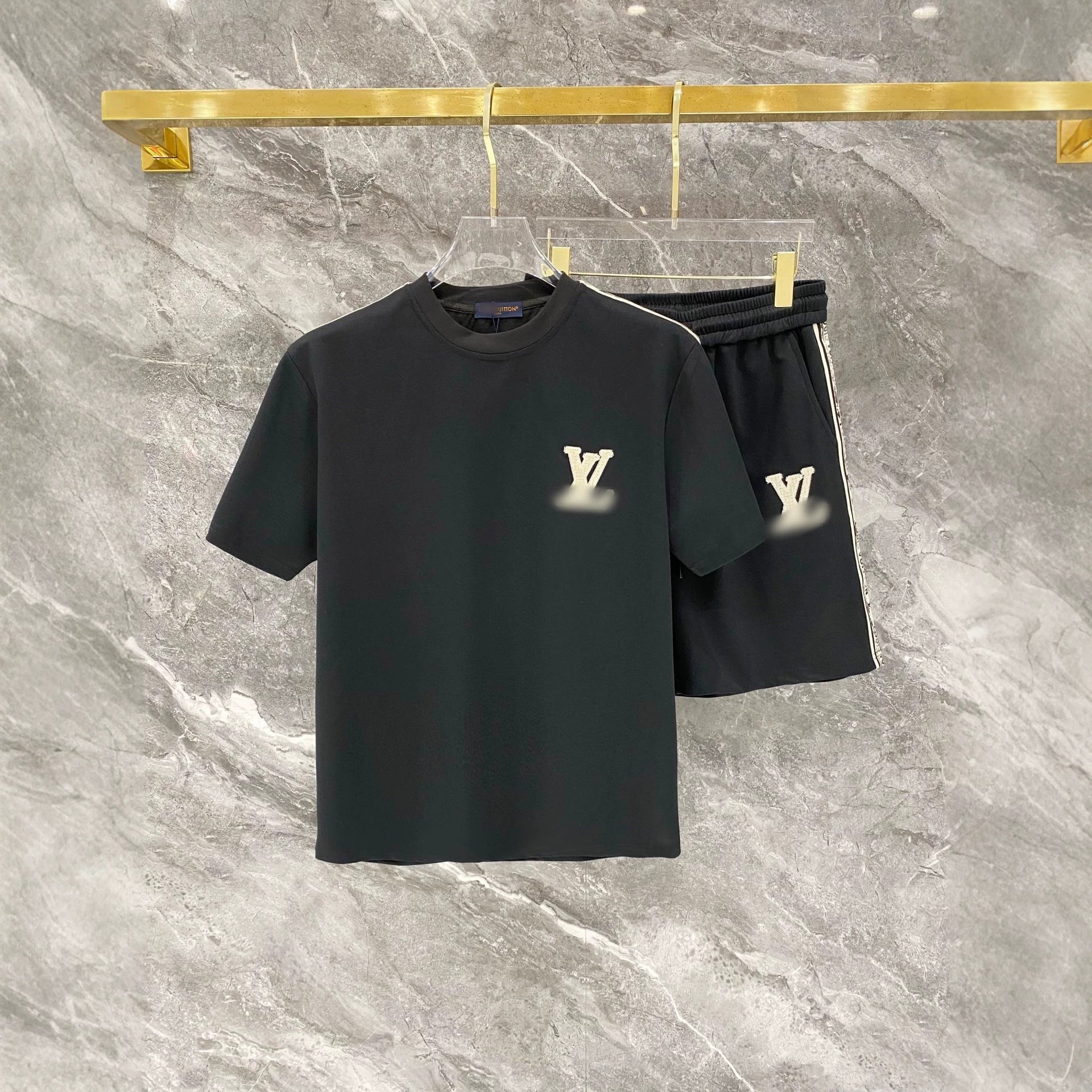 Black t-shirt and shorts set with brand logo on a marble background