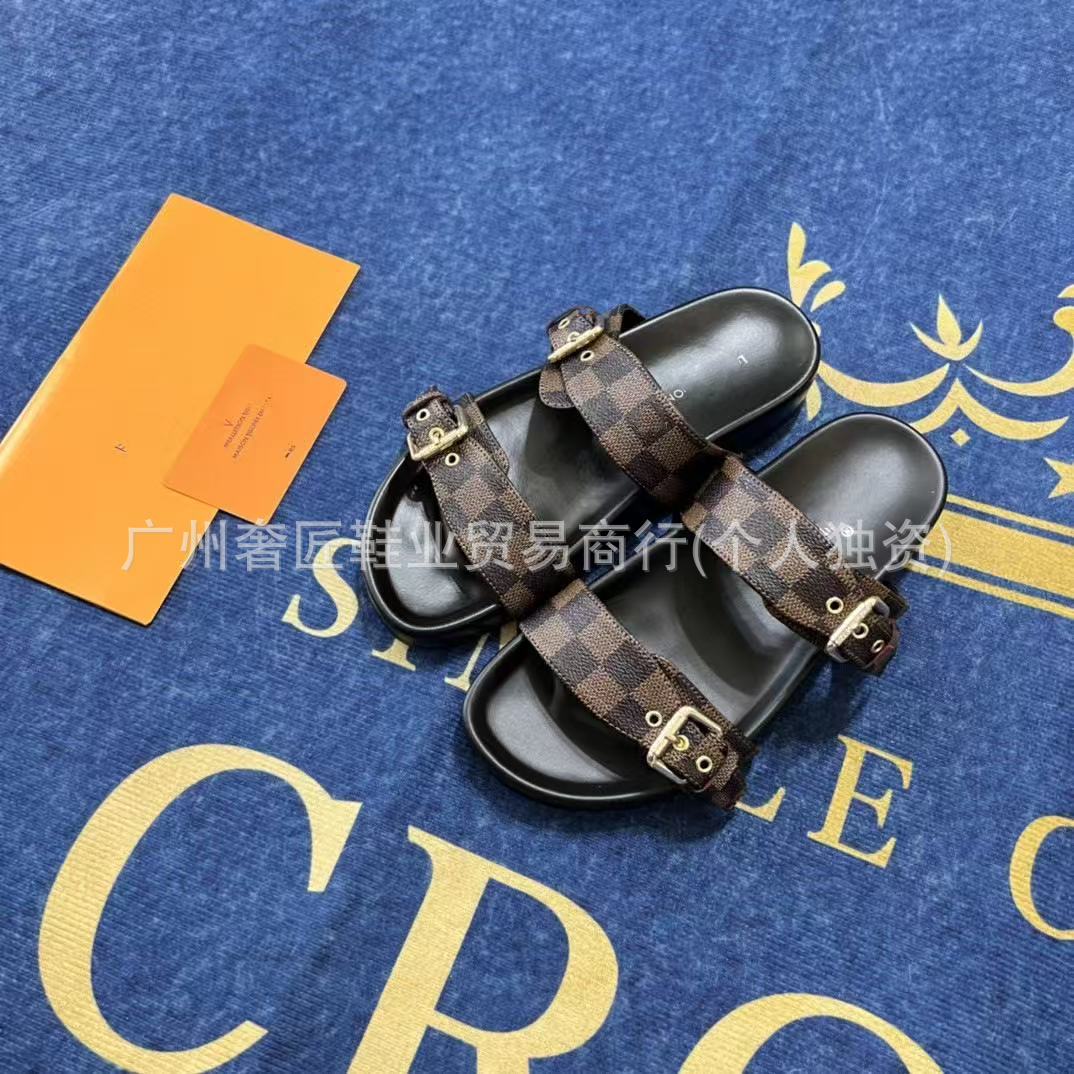 Black sandals with brown checkered straps on a blue surface with gold text