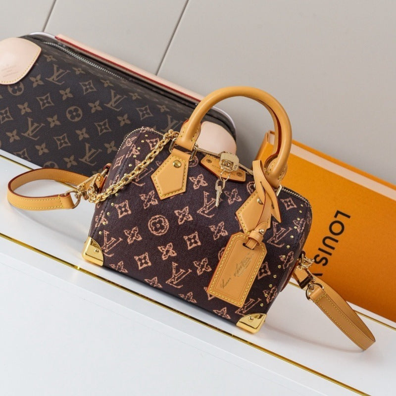 A Louis Vuitton monogram handbag in dark brown coated canvas with tan leather trim and gold-tone hardware, shown with a matching zip pouch and orange Louis Vuitton box on a clean white surface.