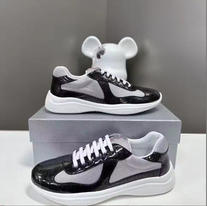 Black and white sneakers on a box with a gray background