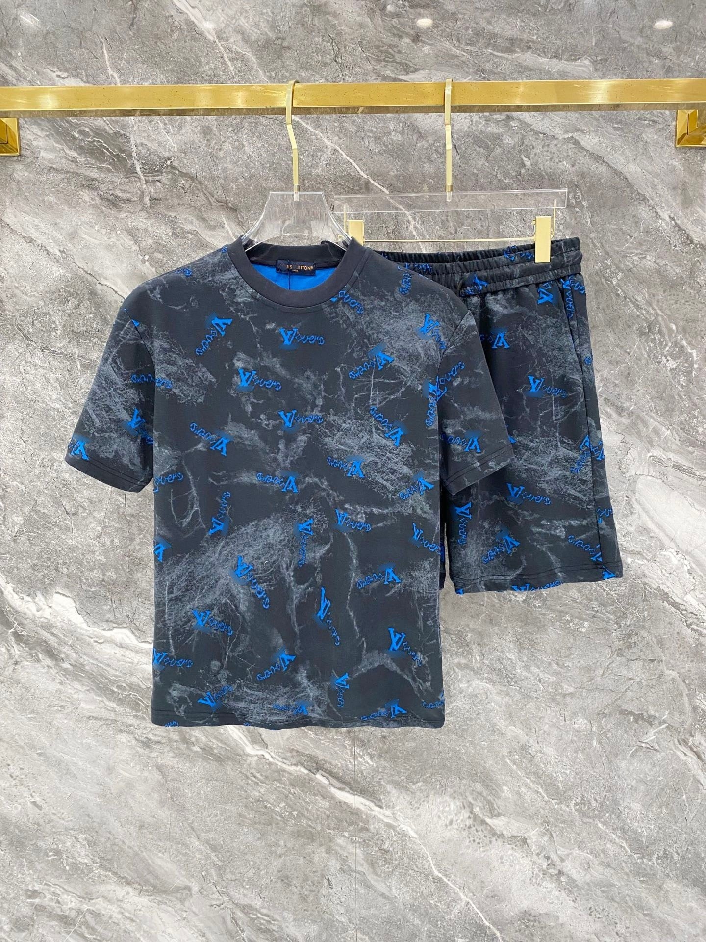 Blue and gray patterned t-shirt and shorts set on a marble surface