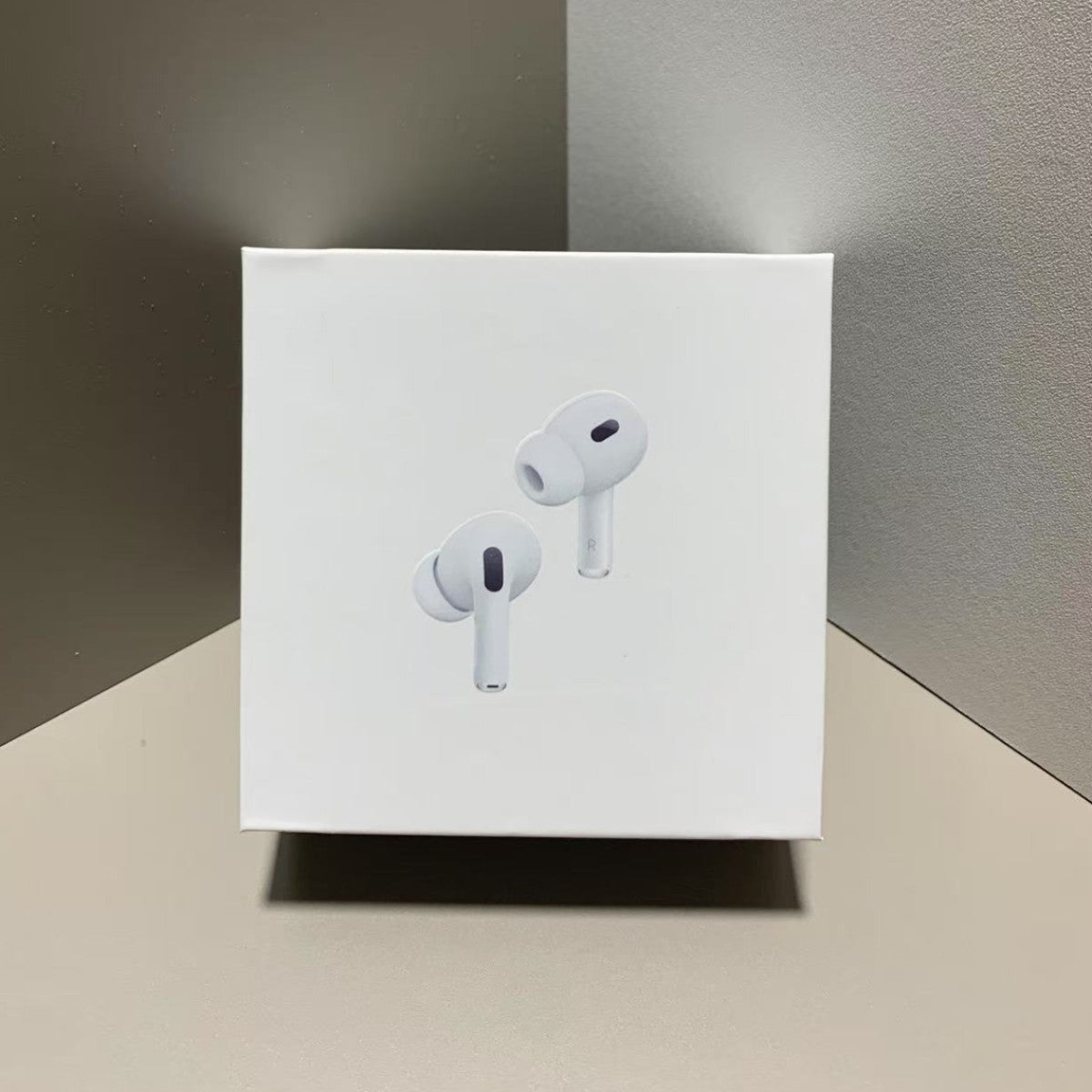White wireless earbuds on a white box against a gray background