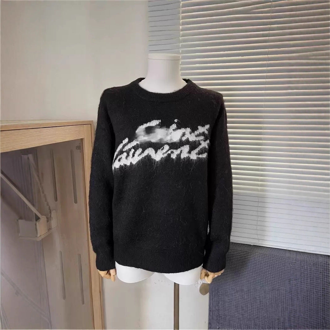 A black fuzzy knit sweater with a white 'Cins Laurent' logo across the chest, displayed on a white mannequin torso in front of window blinds.