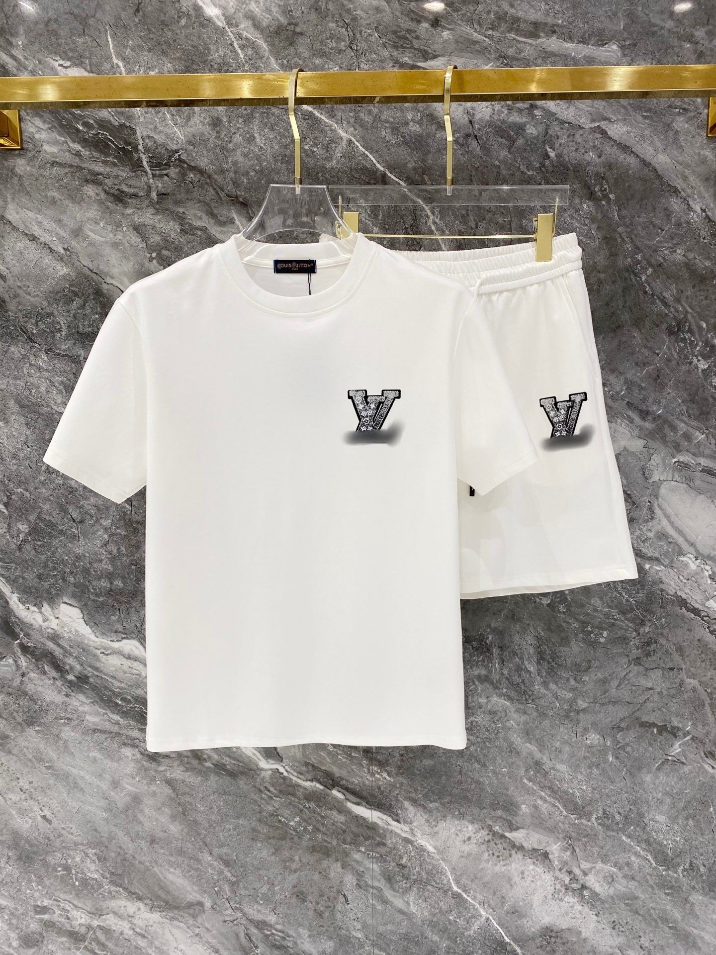 White t-shirt and shorts set with logo on a marble surface