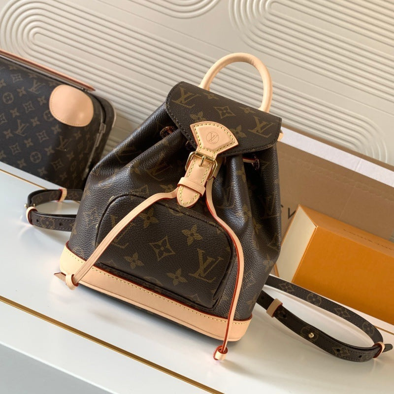Louis Vuitton monogram canvas backpack with light tan leather trim, top handle, and drawstring closure, displayed on a white surface with a matching pouch and box in the background.