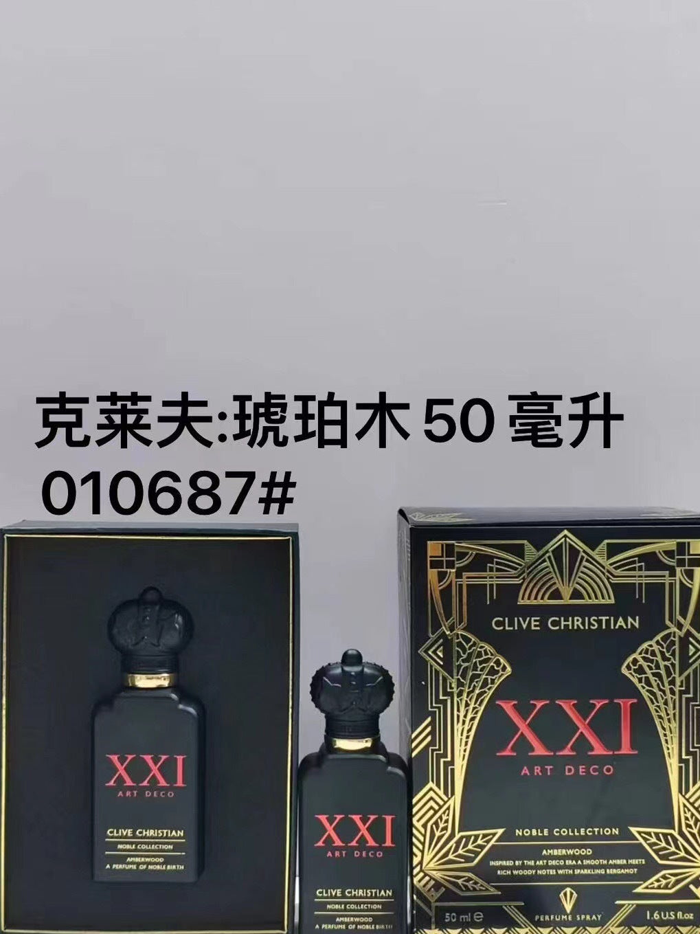 Clive Christian XXI Art Deco perfume bottle and its packaging box, shown alongside a larger matching box. The bottle and smaller bottle are black with gold details and red 'XXI' lettering.