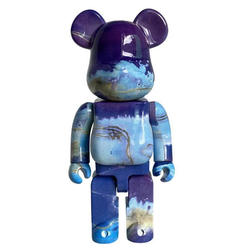 A bear-shaped collectible figure with a glossy marbled resin finish in shades of purple, blue, and white, set against a plain white background.