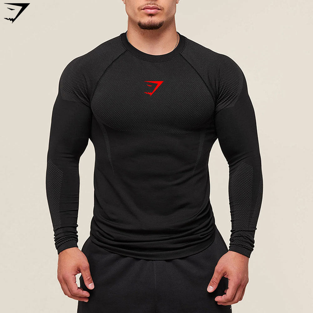 Person wearing a black long-sleeve athletic shirt with a red logo on a beige background