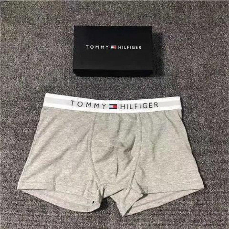 Gray Tommy Hilfiger boxer briefs with a matching box on a gray background