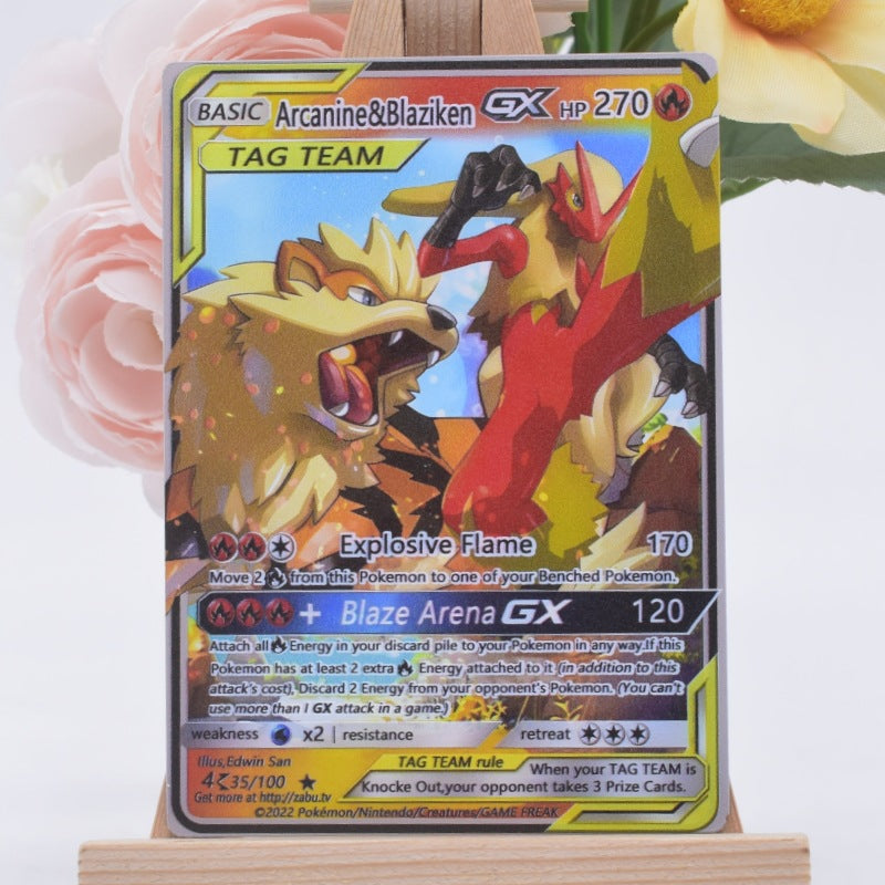 A holographic Pokémon trading card featuring Arcanine and Blaziken, displayed on a small wooden stand with soft pink and yellow flowers in the background.